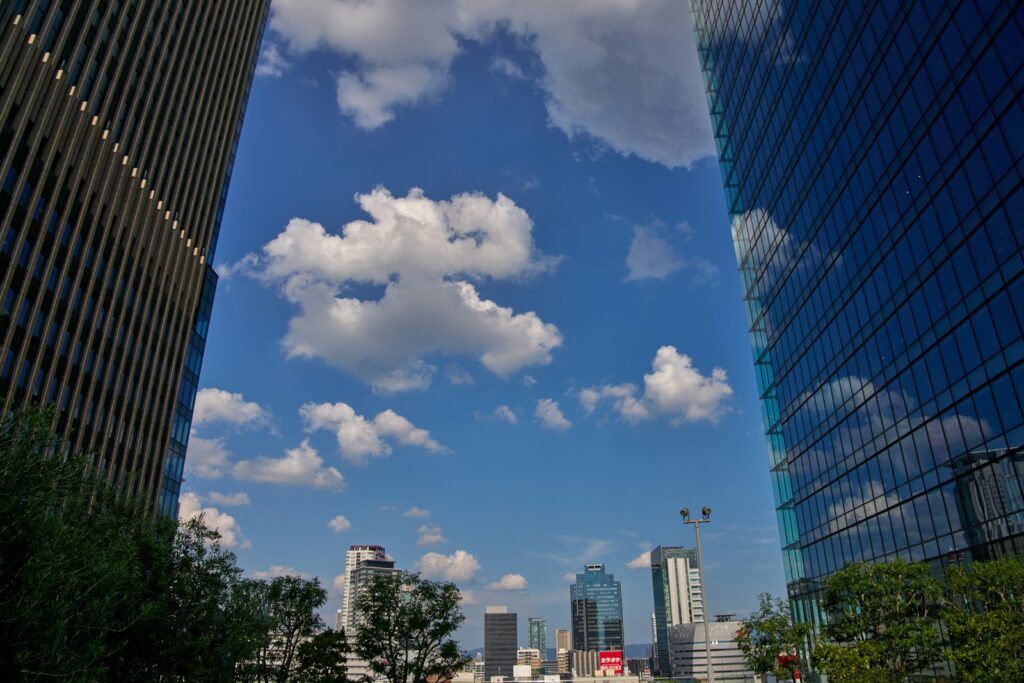 A city street with tall buildings and clouds in the sky